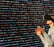 une femme avec un casque de réalité virtuelle devant un mur de lignes de code