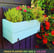 handmade planter box painted in blue with flowers and herbs