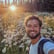 a man with a backpack on a field of flowers