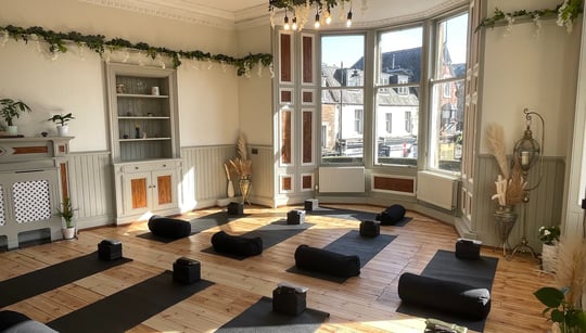 a room with a lot of yoga mats and a fireplace