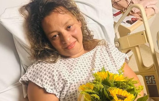 a woman in a hospital bed with a bouquet of sunflowers