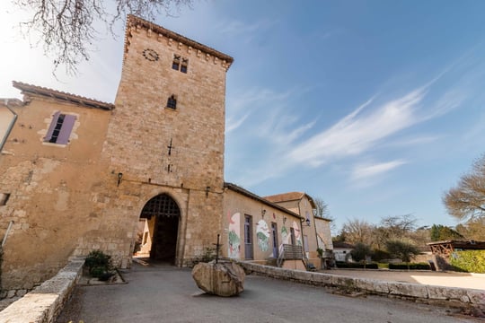 Entrée de la bastide de Sarrant sous un ciel bleu, mise en valeur du patrimoine gersois en photo