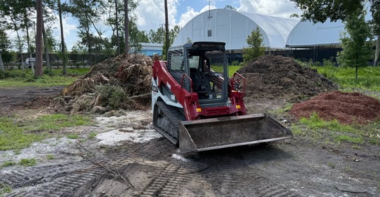 a tractor with a loader on a dirt road