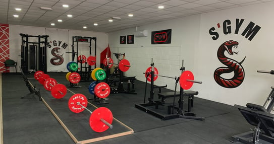 a gym room with a bunch of different colored gym equipment