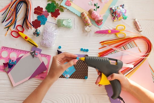 a person is using a glue gun to make a craft