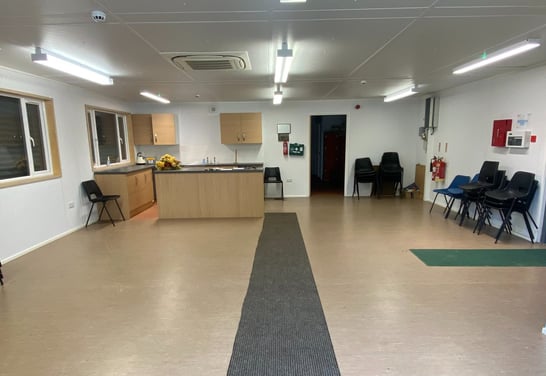 a room with a large open space with chairs and a table