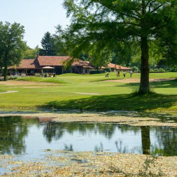a golf course with a pond and a golf course golf club de la bresse