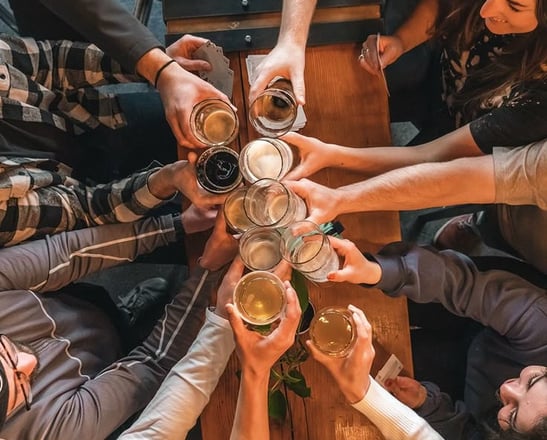 a group of people at the Riga Pub Crawl standing around a table with beer glasses