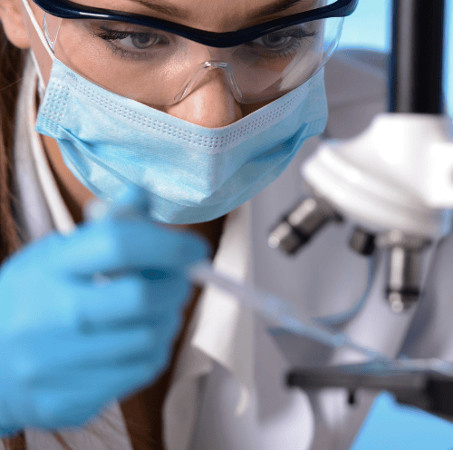 a woman in a lab coat and a mask on