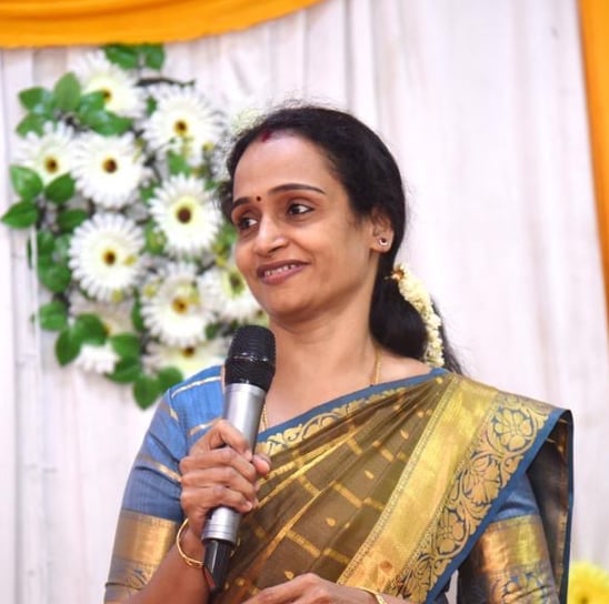 Vijapriya Ganeshjeevan holding a microphone