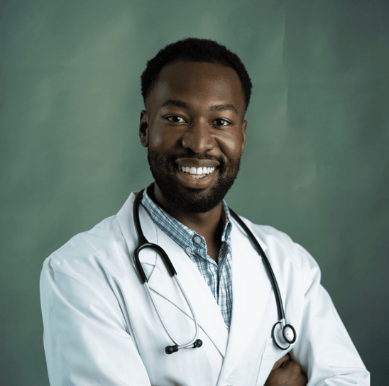 Médico negro sorrindo com estetoscópio no pescoço e braços cruzados