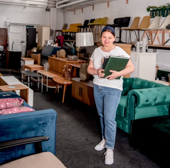 Simona, founder of Exdi Home and Exdi Furniture, standing in her Nottingham showroom surrounded by s