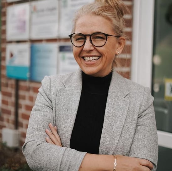 a woman in glasses and a gray jacket therapist psychotherapy