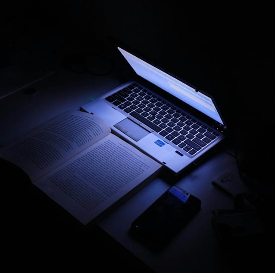 a laptop computer sitting on a desk with a cell phone and a cell phone