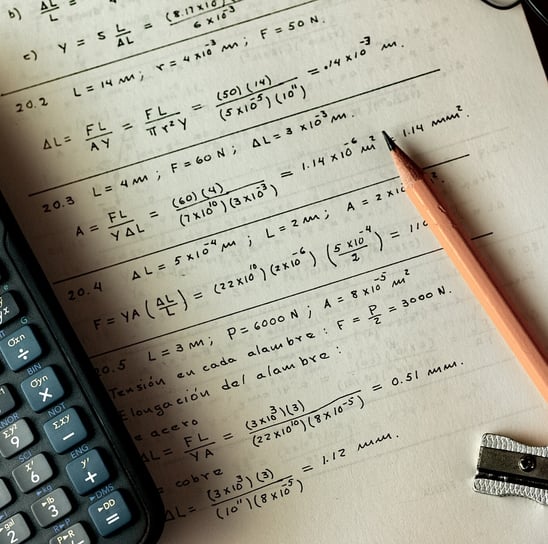 a calculator and a pencil and pencil on a notebook