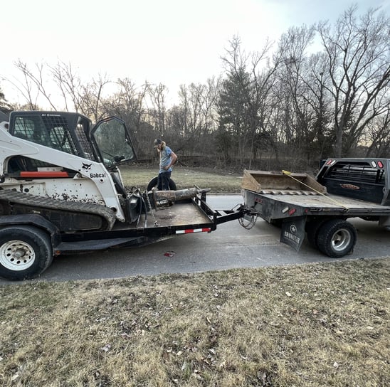 truck with skid steer on trailer