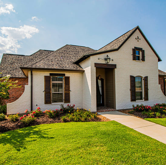 Photo of rancher style house basking in mid-day sunshine.