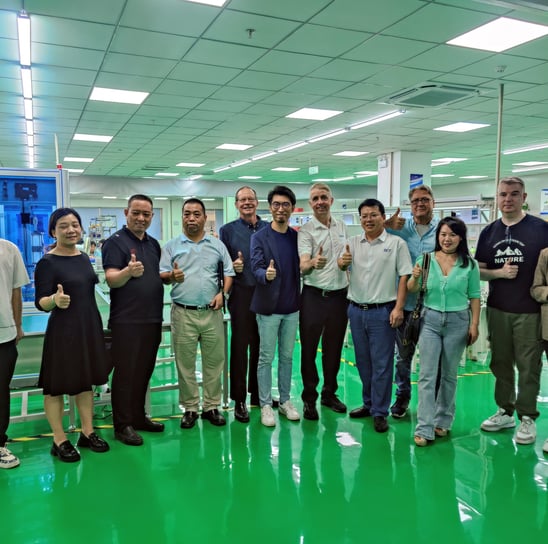 a group of people standing in a factory with thumbs up