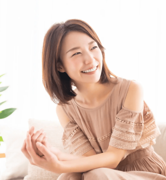 骨盤矯正後に笑顔を見せる日本人女性。安心感と健康を実感するイメージ。