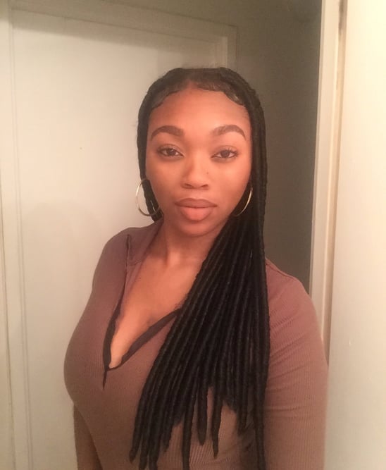 a woman with long hair and a brown top
