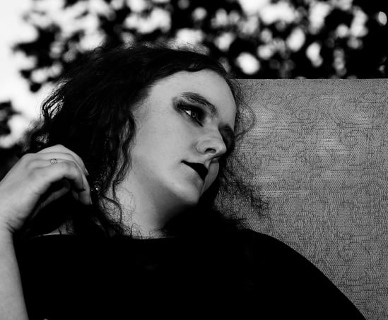 a woman with long hair and a black shirt sitting outdoor