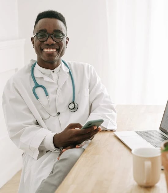 a male doctor in a white lab coat and a laptop