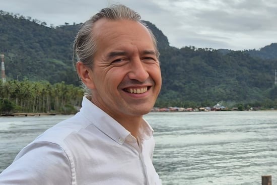 Photo of Rico Wallenta standing by the water in Sungai Pisang, West Sumatra