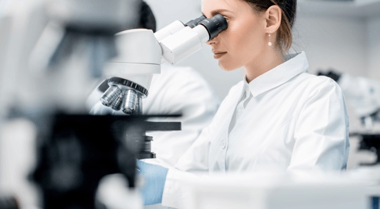 Scientist examining samples under a microscope in the research laboratory