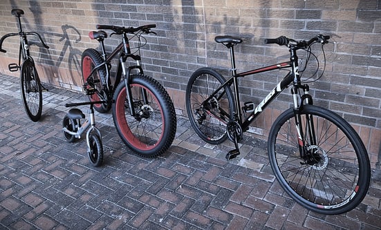 two bikes parked next to each other on a brick wall