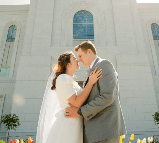 a bride and groom standing in front of a church