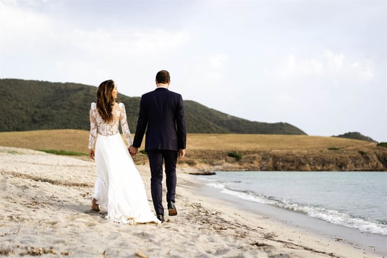 Editorial fine art wedding photo of bride and groom walking on a South of France beach