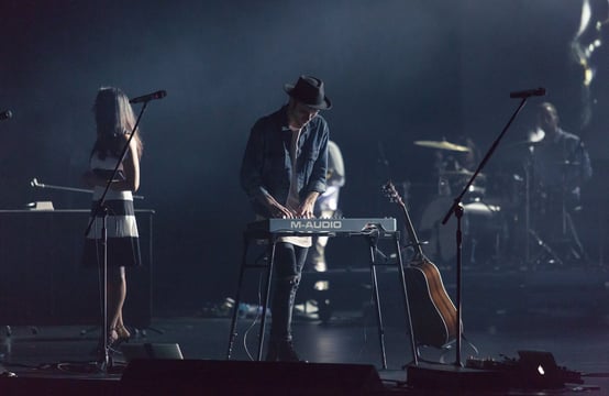 a man playing a keyboard on stage with a keyboard