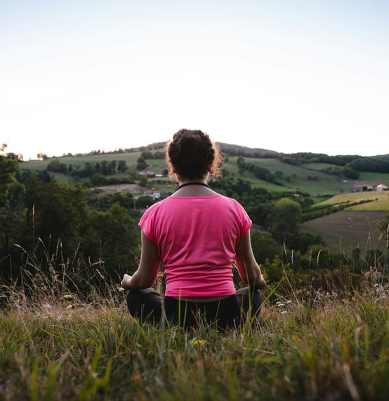 Young woman meditating in the countryside.