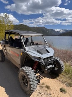 a Polaris RZR parked near Georgetown Lake with the Rocky Mountains in the distance