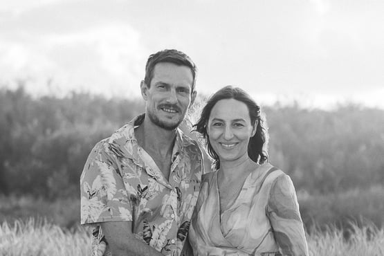 family business owners standing in front of dunes and bush