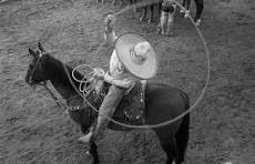 a man in a cowboy hat and a lasset
