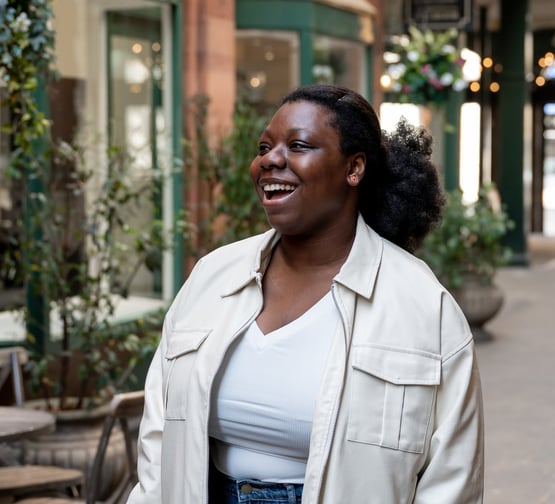 a black woman in a white jacket and jeans portrait photography