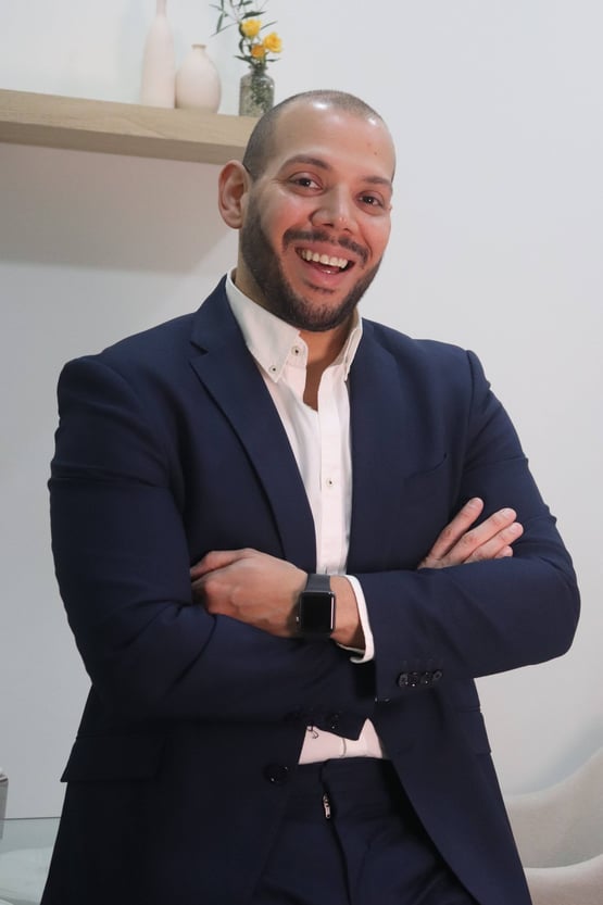 a man in a suit and white shirt smiling