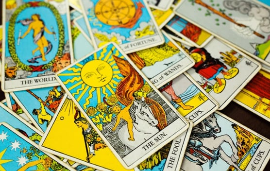 a pile of tarot cards with a sunflower on top