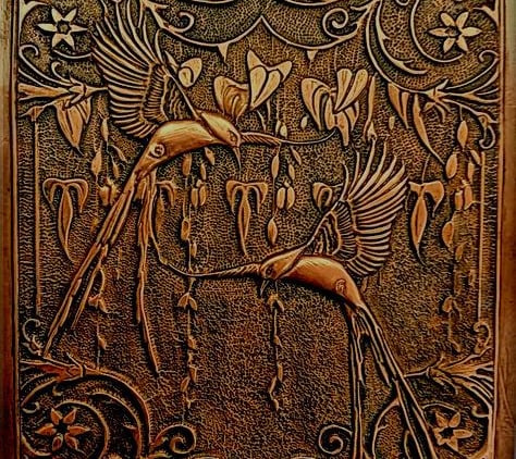 a decorative wooden paneled wall hanging with a bird