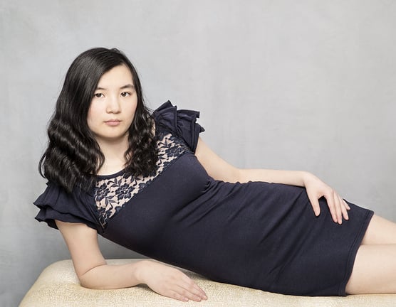 Photograph of a beautiful young woman reclining on a bench