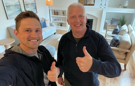 Happy customer posing with Alex, Vision Flooring. On the background there is part of the work we did