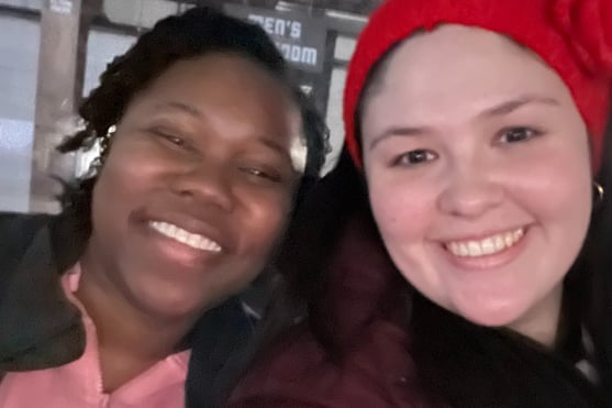 two women standing next to each other and smiling