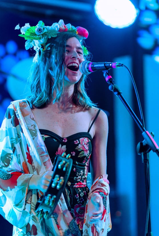 a woman in a floral dress singing into a microphone
