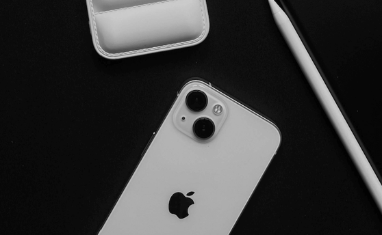 iPhone Km0 blanco junto a su estuche y accesorios, destacando la experiencia de compra completa en Plant Your Phone.