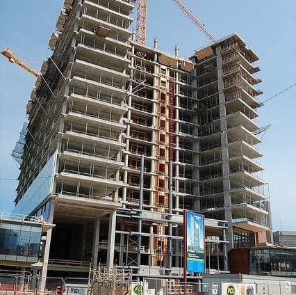 a large building with a crane in the foreground