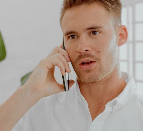 Homme au téléphone demandant un devis pour un service de débarras en Suisse romande