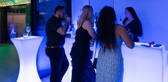 Three guests waiting at the LED glow bar to be served by the bartender at a party in Redland Bay.