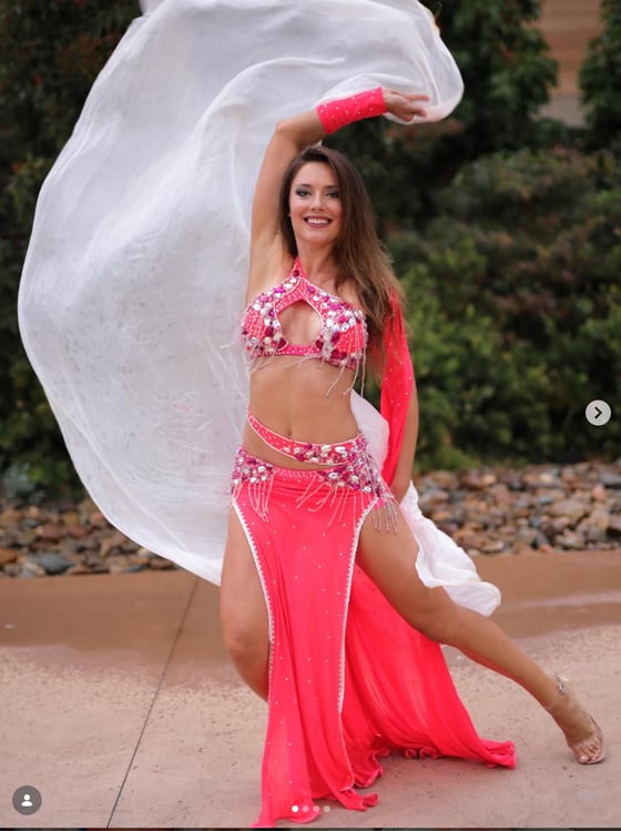 Coral costume with a white silk veil in motion