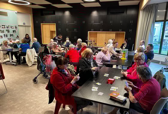 Groupe de seniors participant à une animation de jeux de société, guidés dans un cadre convivial